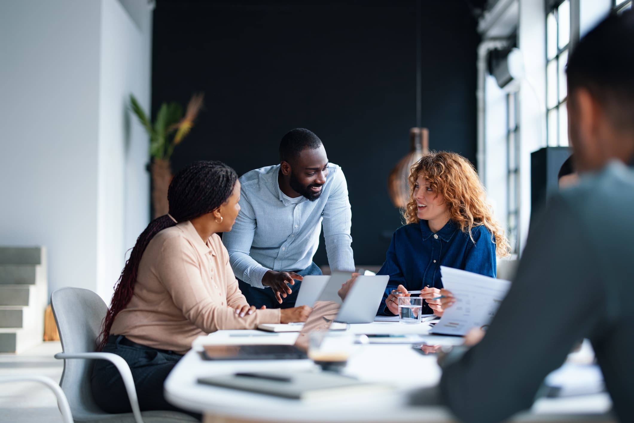 Consultant accompagnant une équipe cliente autour d'une table de travail
