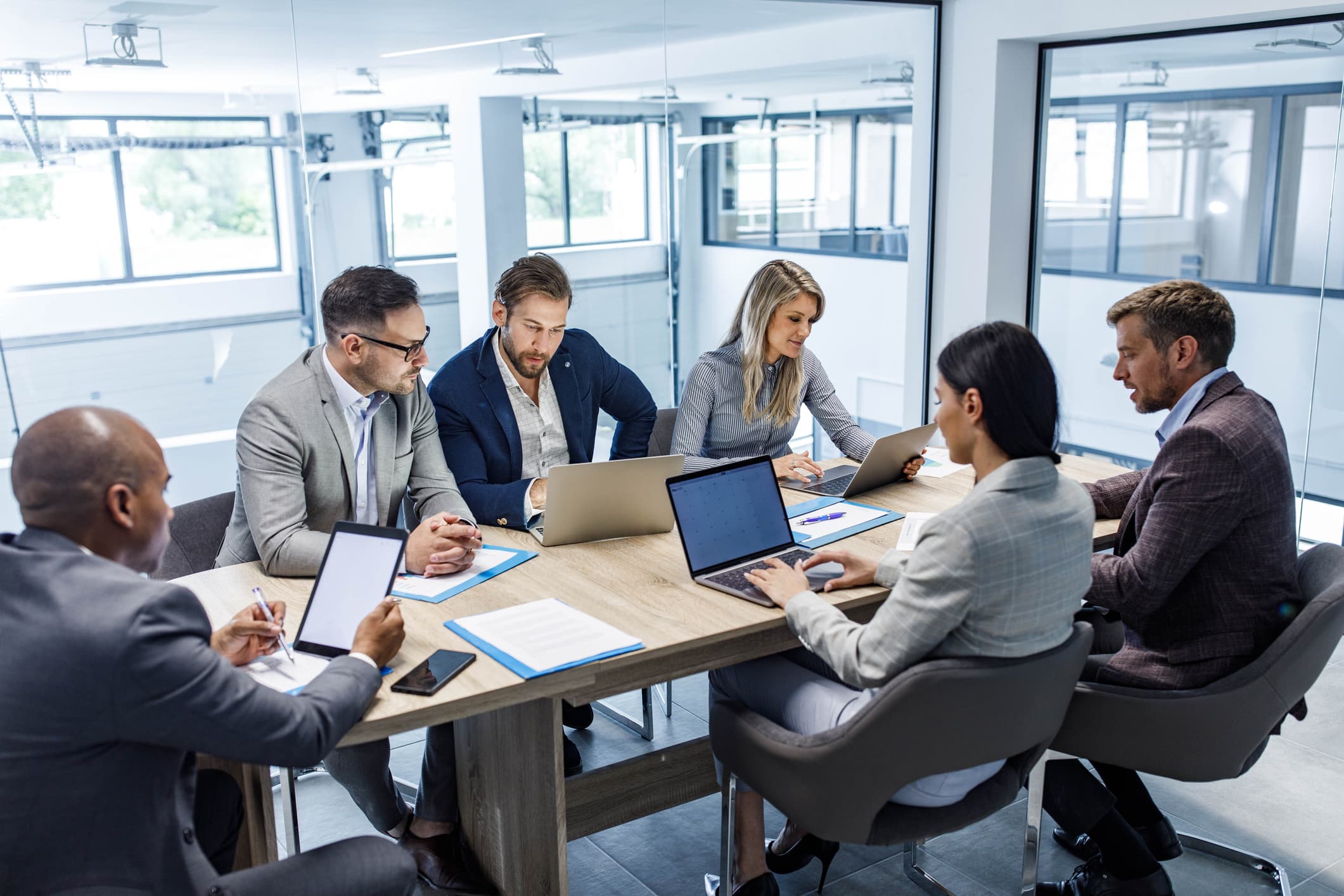 Équipe de direction en réunion autour d'une table dans un bureau lumineux